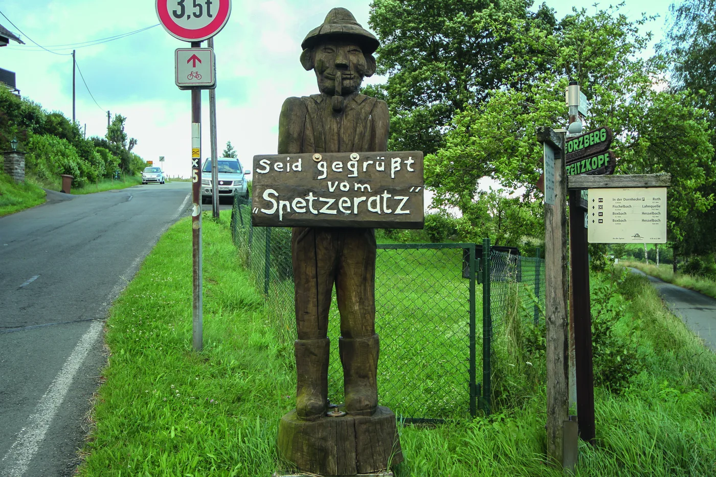 Hölzerne Wegfigur am Straßenrand